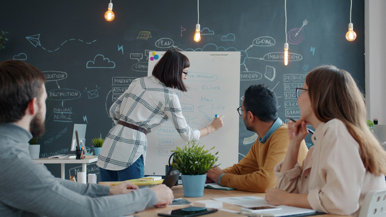 Colleagues discussing ideas together around a whiteboard