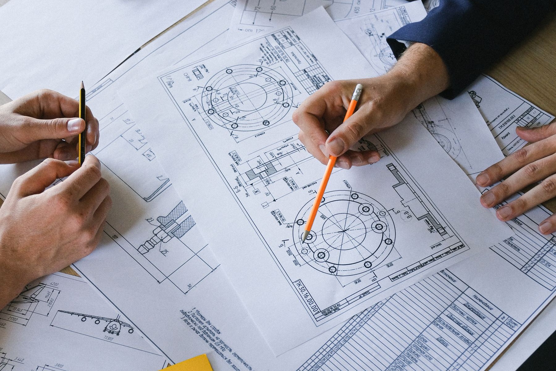 Colleagues reviewing technical plans and engineering diagrams together