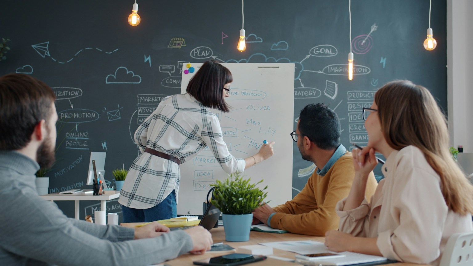 Colleagues reviewing a business workflow together at a whiteboard